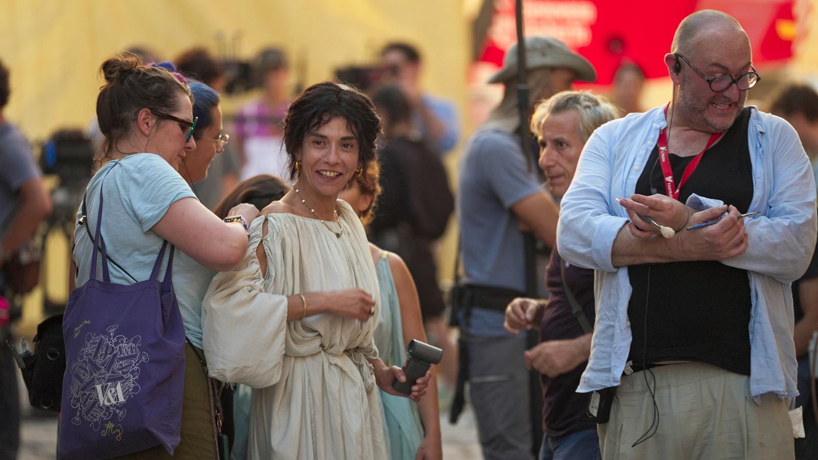 Cecile van Dijk adjusting an actress's Roman costume on the set of Pompeii: Out of Time with Tom Hiddleston